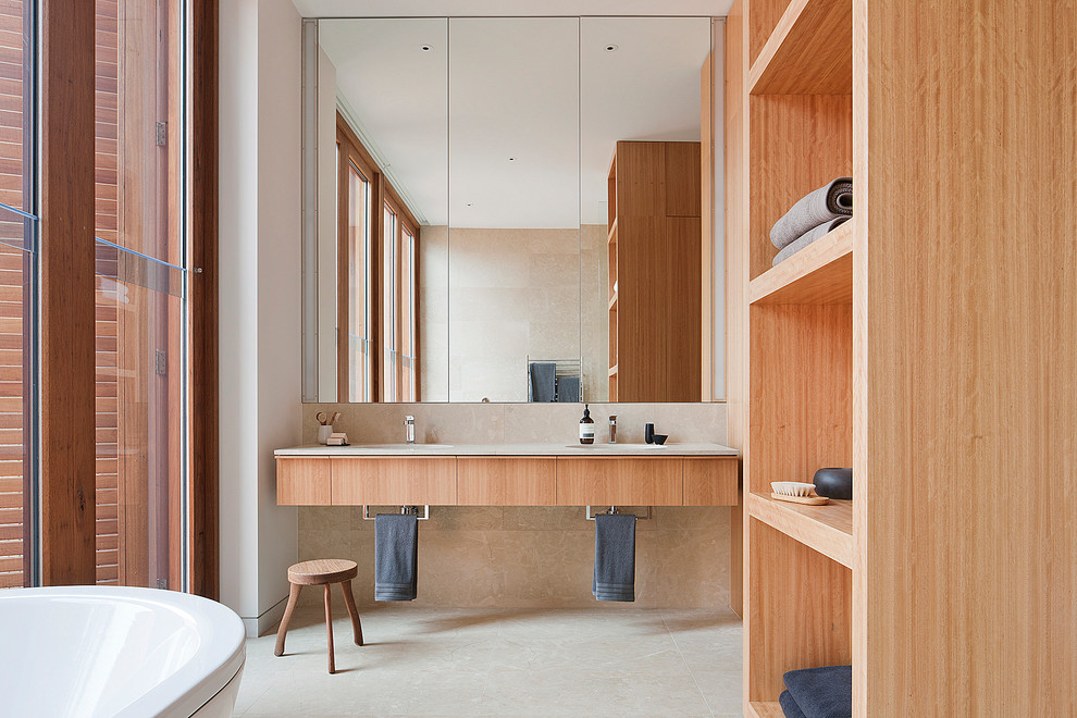 Réalisation d'une salle de bain minimaliste en bois clair avec un placard à porte plane, un carrelage beige et un mur blanc.