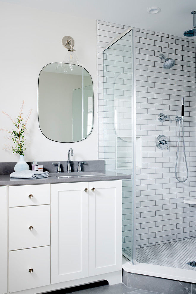 Photo of a coastal shower room bathroom in Portland Maine with shaker cabinets, white cabinets, a corner shower, white tiles, metro tiles, white walls, a submerged sink, grey floors and grey worktops.