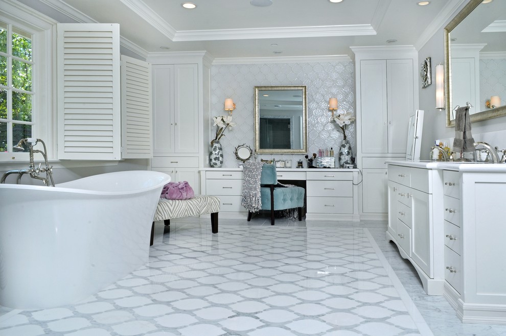 Cette image montre une salle de bain traditionnelle avec un placard à porte plane, des portes de placard blanches, une baignoire indépendante, un carrelage blanc et un mur blanc.