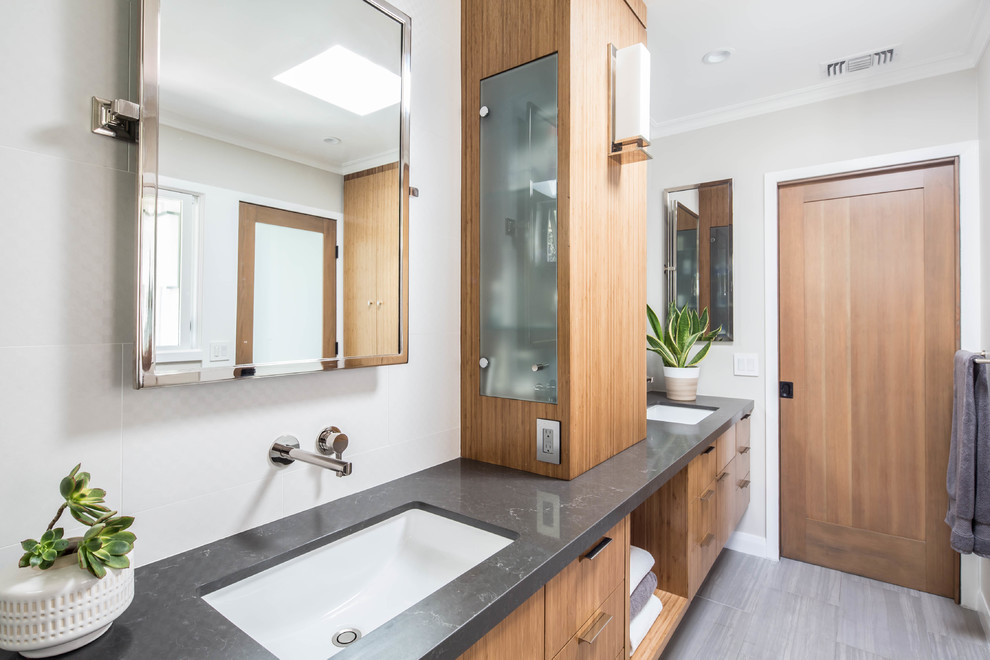 Cette photo montre une salle de bain tendance avec un placard à porte plane, des portes de placard marrons, un mur gris, un lavabo encastré, un sol gris et un plan de toilette gris.