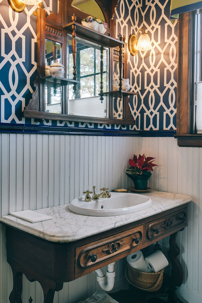 Foto di una stanza da bagno chic con lavabo da incasso, ante in legno bruno, pareti multicolore e ante con riquadro incassato