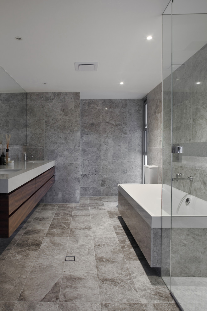 Ejemplo de cuarto de baño contemporáneo con armarios con paneles lisos, puertas de armario de madera en tonos medios, baldosas y/o azulejos grises y paredes grises