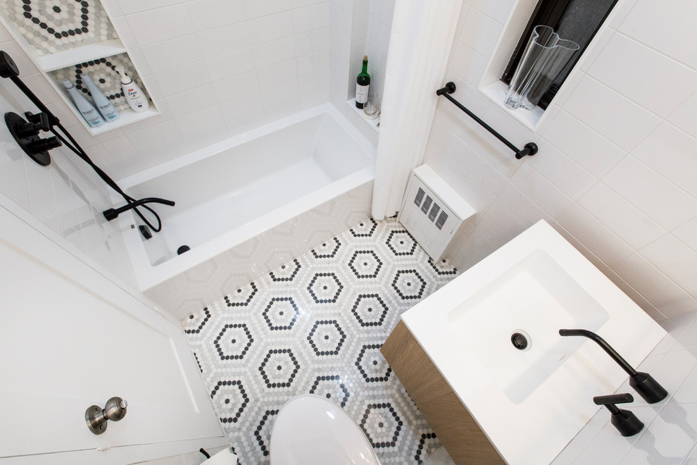 Idéer för att renovera ett mellanstort funkis vit vitt en-suite badrum, med släta luckor, skåp i mellenmörkt trä, ett badkar i en alkov, en dusch/badkar-kombination, en vägghängd toalettstol, vit kakel, porslinskakel, vita väggar, marmorgolv, ett väggmonterat handfat, bänkskiva i akrylsten, flerfärgat golv och dusch med duschdraperi