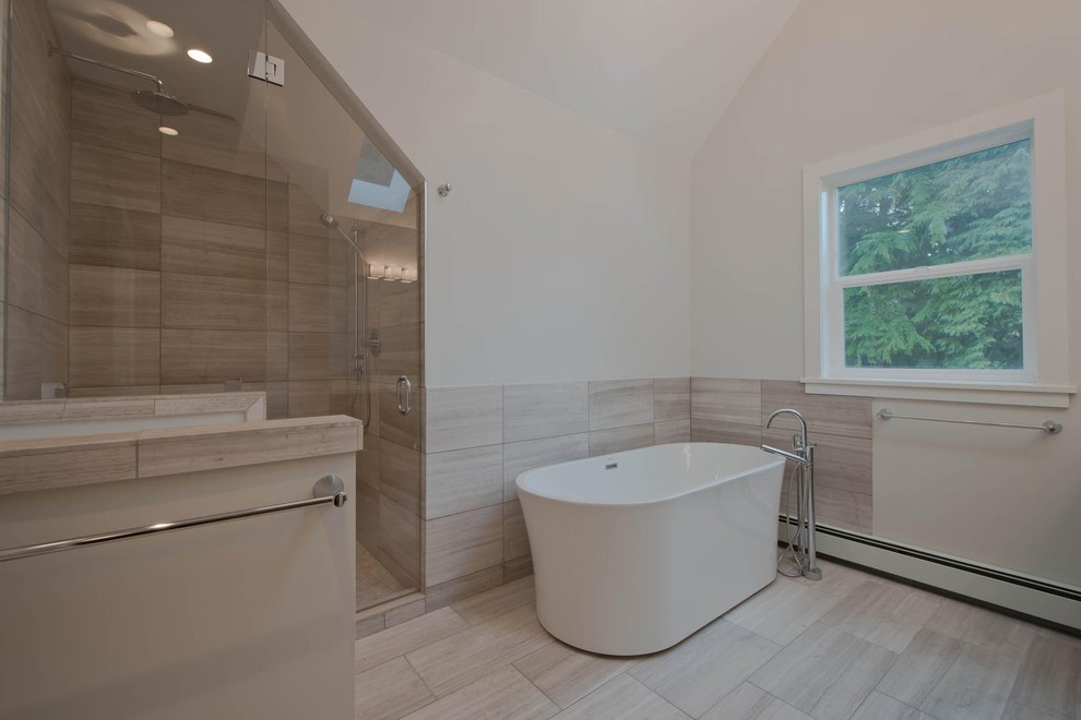 This is an example of a large contemporary ensuite bathroom in Vancouver with shaker cabinets, dark wood cabinets, a freestanding bath, an alcove shower, white walls, light hardwood flooring, a submerged sink, solid surface worktops, beige tiles and porcelain tiles.