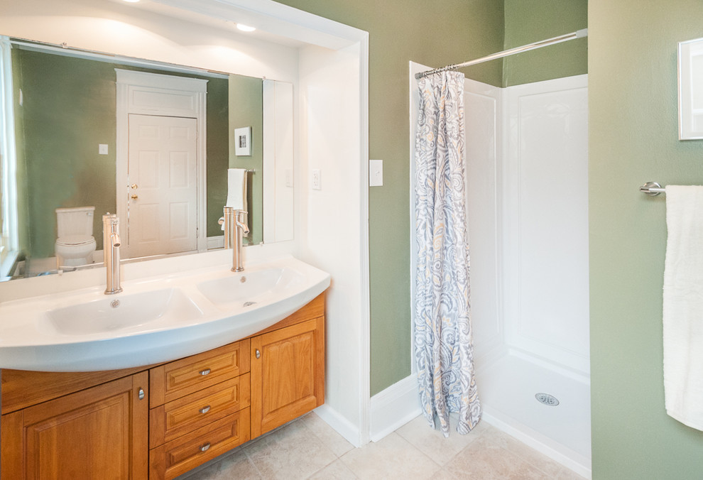 Diseño de cuarto de baño actual de tamaño medio con armarios con paneles con relieve, puertas de armario de madera clara, paredes verdes, suelo de baldosas de cerámica y lavabo de seno grande