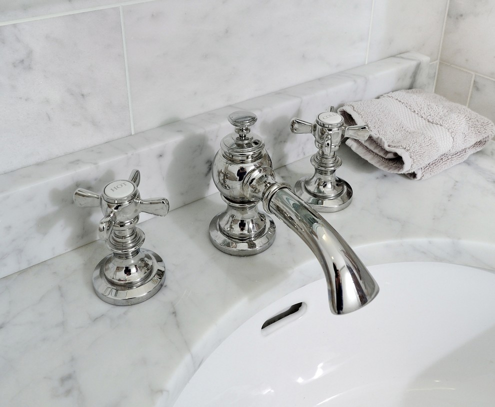 Immagine di una piccola stanza da bagno contemporanea con lavabo integrato, ante con bugna sagomata, ante bianche, top in marmo, WC a due pezzi, piastrelle bianche, pareti grigie e parquet scuro