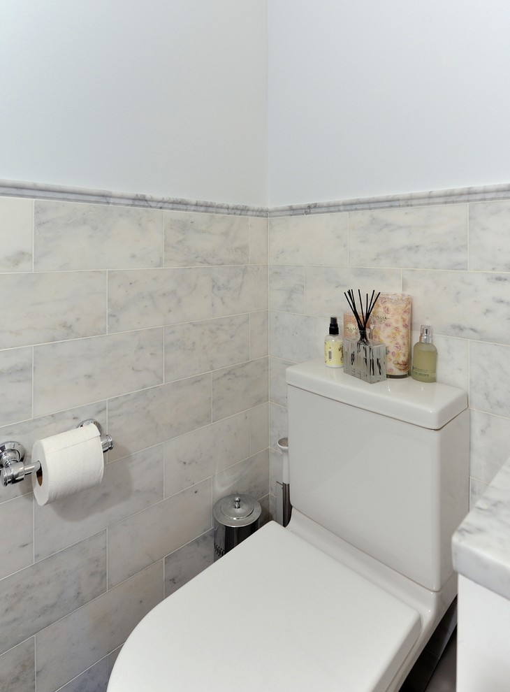 Kleines Modernes Badezimmer mit integriertem Waschbecken, profilierten Schrankfronten, weißen Schränken, Marmor-Waschbecken/Waschtisch, Wandtoilette mit Spülkasten, weißen Fliesen, grauer Wandfarbe und dunklem Holzboden in New York