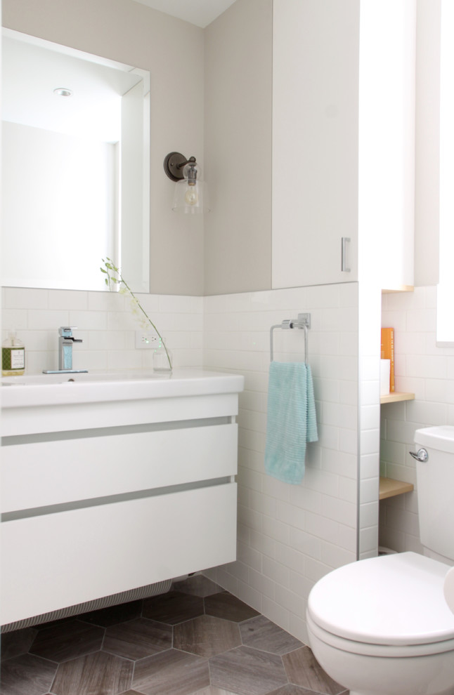 Idéer för små funkis badrum för barn, med släta luckor, vita skåp, ett badkar i en alkov, en dusch/badkar-kombination, en bidé, vit kakel, keramikplattor, vita väggar, klinkergolv i porslin och ett integrerad handfat
