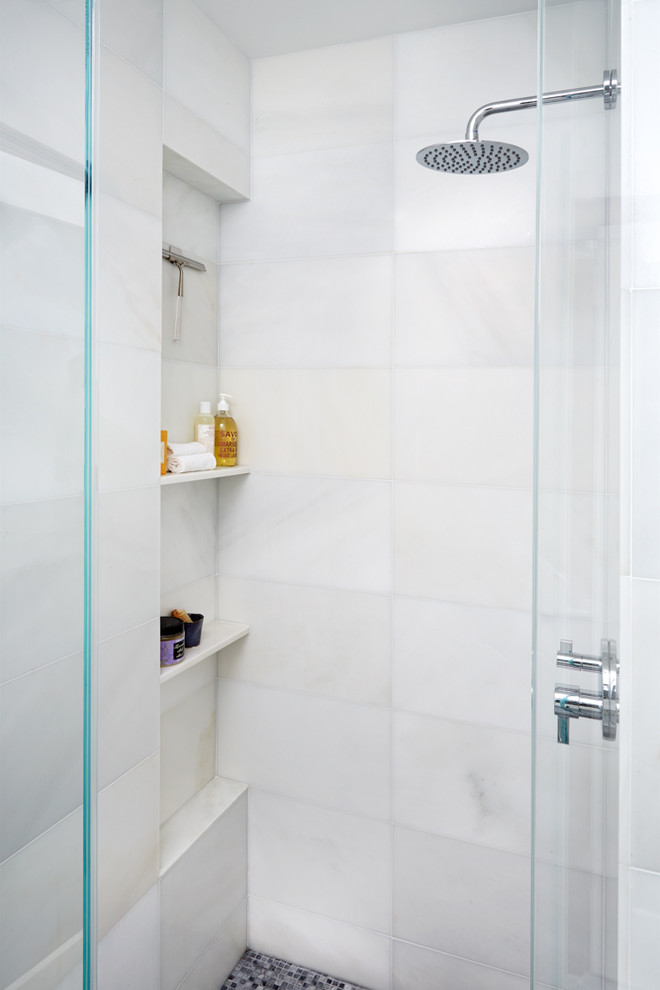 Inspiration for a small contemporary ensuite bathroom in New York with flat-panel cabinets, white cabinets, a built-in bath, a built-in shower, a one-piece toilet, marble tiles, white walls, marble flooring, a wall-mounted sink, grey floors and a hinged door.