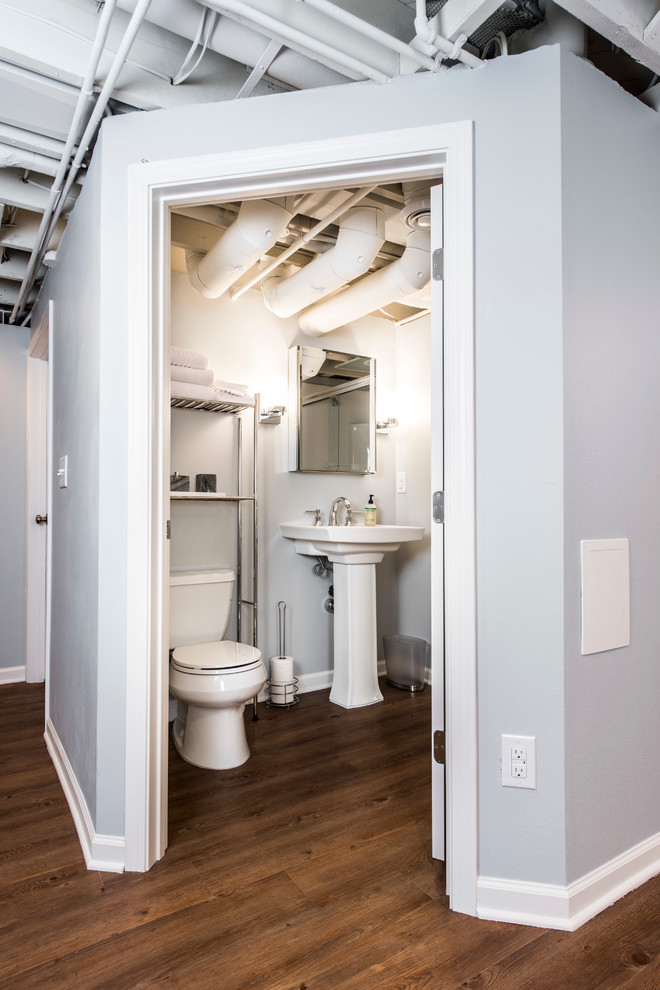 Cette image montre une salle de bain traditionnelle de taille moyenne avec WC séparés, un mur gris, parquet foncé et un lavabo de ferme.