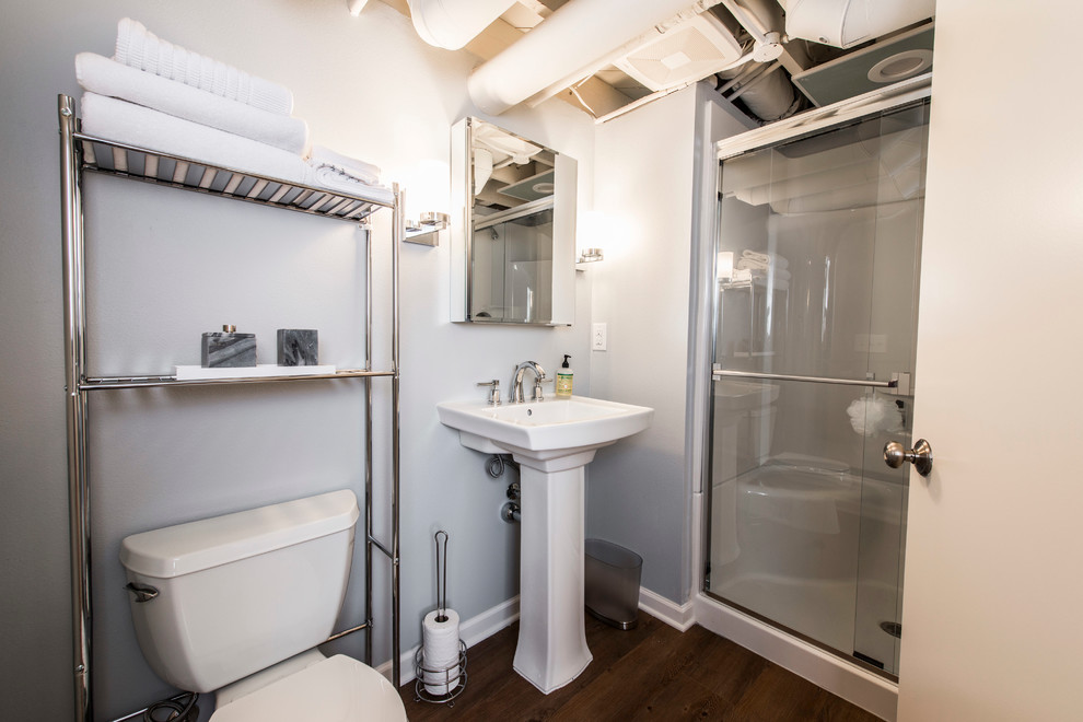 Mittelgroßes Klassisches Duschbad mit Duschnische, Wandtoilette mit Spülkasten, grauer Wandfarbe, dunklem Holzboden und Sockelwaschbecken in Milwaukee