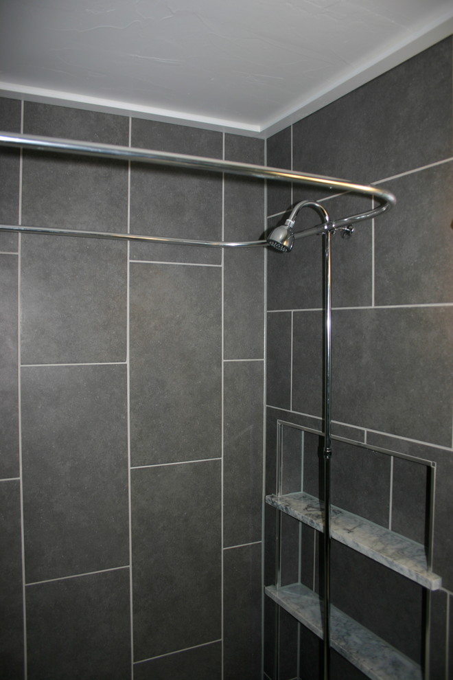 Foto på ett mellanstort vintage badrum med dusch, med ett badkar med tassar, en dusch/badkar-kombination, en toalettstol med separat cisternkåpa, grå kakel, keramikplattor, grå väggar, klinkergolv i keramik och ett piedestal handfat