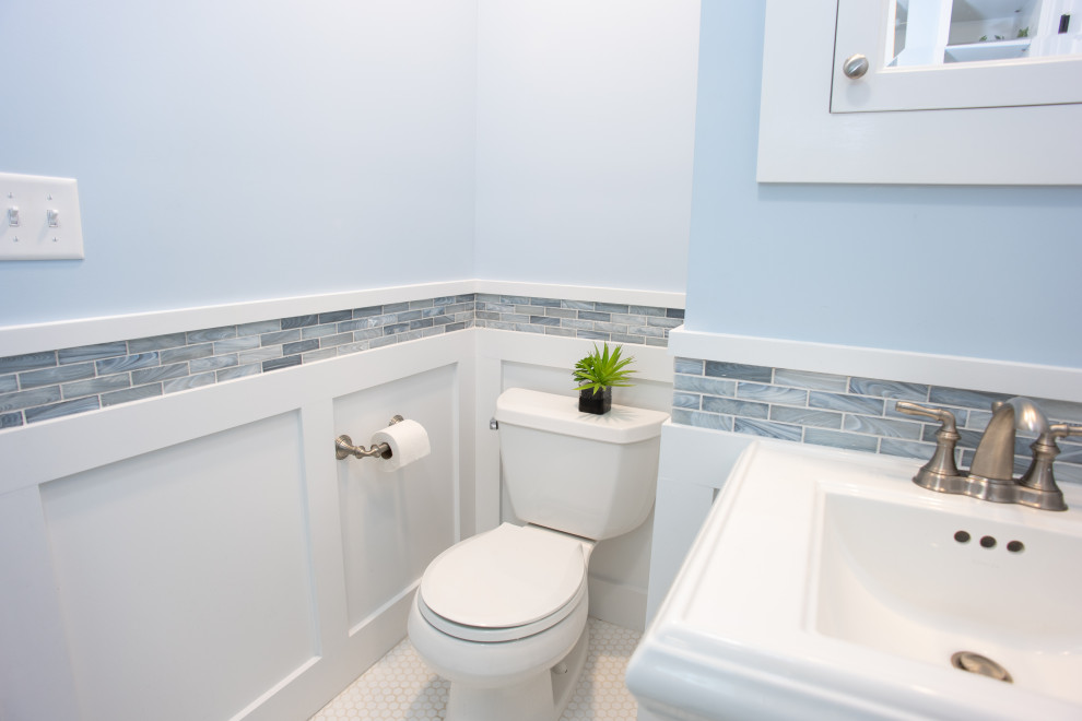 Cette image montre une petite salle de bain principale craftsman avec des portes de placard blanches, une douche ouverte, WC séparés, un carrelage bleu, un carrelage en pâte de verre, un mur bleu, un sol en carrelage de céramique, un lavabo de ferme, un sol multicolore, une cabine de douche à porte coulissante, une niche, meuble simple vasque, meuble-lavabo sur pied et boiseries.