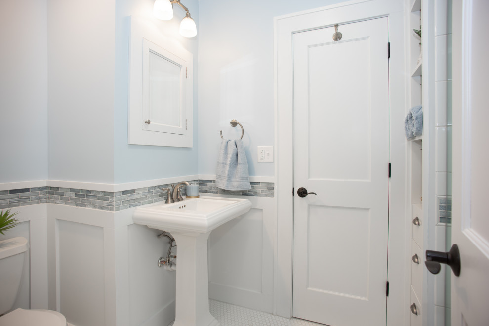 Стильный дизайн: маленькая главная ванная комната в стиле кантри с белыми фасадами, открытым душем, раздельным унитазом, синей плиткой, стеклянной плиткой, синими стенами, полом из керамической плитки, раковиной с пьедесталом, разноцветным полом, душем с раздвижными дверями, нишей, тумбой под одну раковину, напольной тумбой и панелями на стенах для на участке и в саду - последний тренд