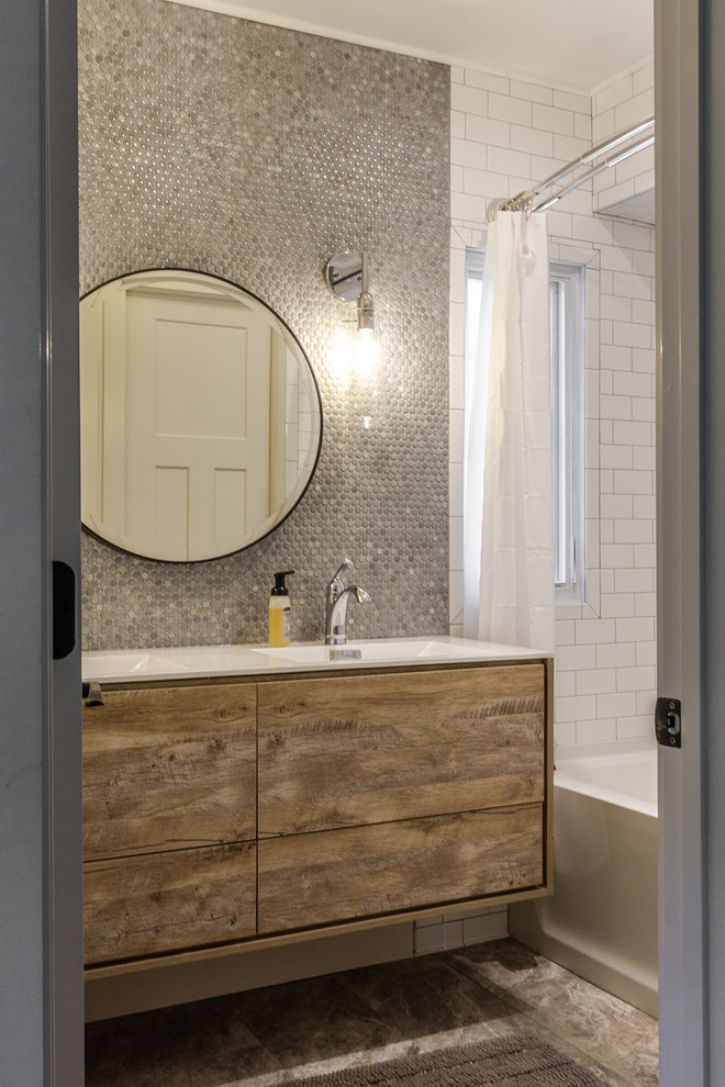 This is an example of a large eclectic family bathroom in Other with freestanding cabinets, light wood cabinets, an alcove bath, a corner shower, a two-piece toilet, grey tiles, ceramic tiles, white walls, ceramic flooring, an integrated sink, laminate worktops, grey floors and white worktops.