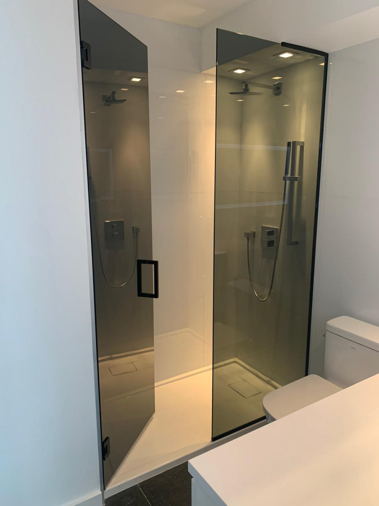 Inspiration for a small modern 3/4 white tile and ceramic tile ceramic tile, black floor and single-sink bathroom remodel in Miami with glass-front cabinets, white cabinets, a one-piece toilet, white walls, a drop-in sink, quartzite countertops, white countertops and a built-in vanity