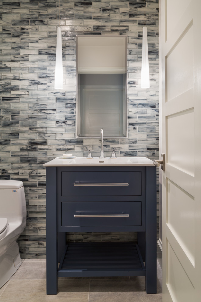 Foto på ett mellanstort funkis vit badrum med dusch, med möbel-liknande, blå skåp, en toalettstol med hel cisternkåpa, keramikplattor, en kantlös dusch, blå kakel, blå väggar, klinkergolv i porslin, ett integrerad handfat, bänkskiva i kvarts, grått golv och dusch med gångjärnsdörr