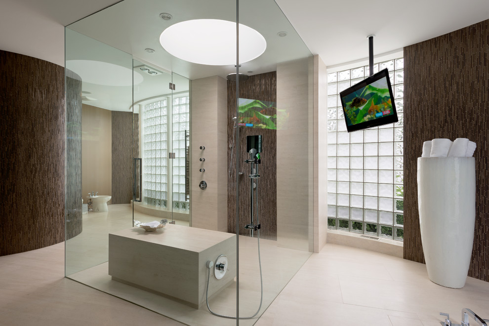 Modern inredning av ett en-suite badrum, med ett fristående handfat, ett undermonterat badkar, en kantlös dusch, stenhäll och kalkstensgolv
