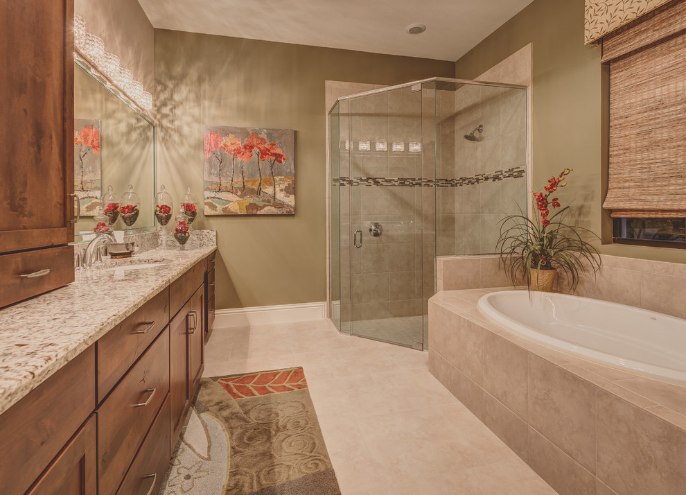 Réalisation d'une petite salle de bain principale tradition en bois brun avec un placard avec porte à panneau encastré, un plan de toilette en granite, une baignoire posée, une douche d'angle, un carrelage beige et un mur vert.