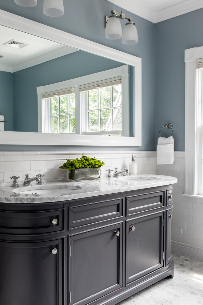 Immagine di una stanza da bagno padronale chic di medie dimensioni con lavabo sottopiano, ante con riquadro incassato, ante grigie, top in marmo, piastrelle bianche, piastrelle in ceramica, pareti blu e pavimento in marmo