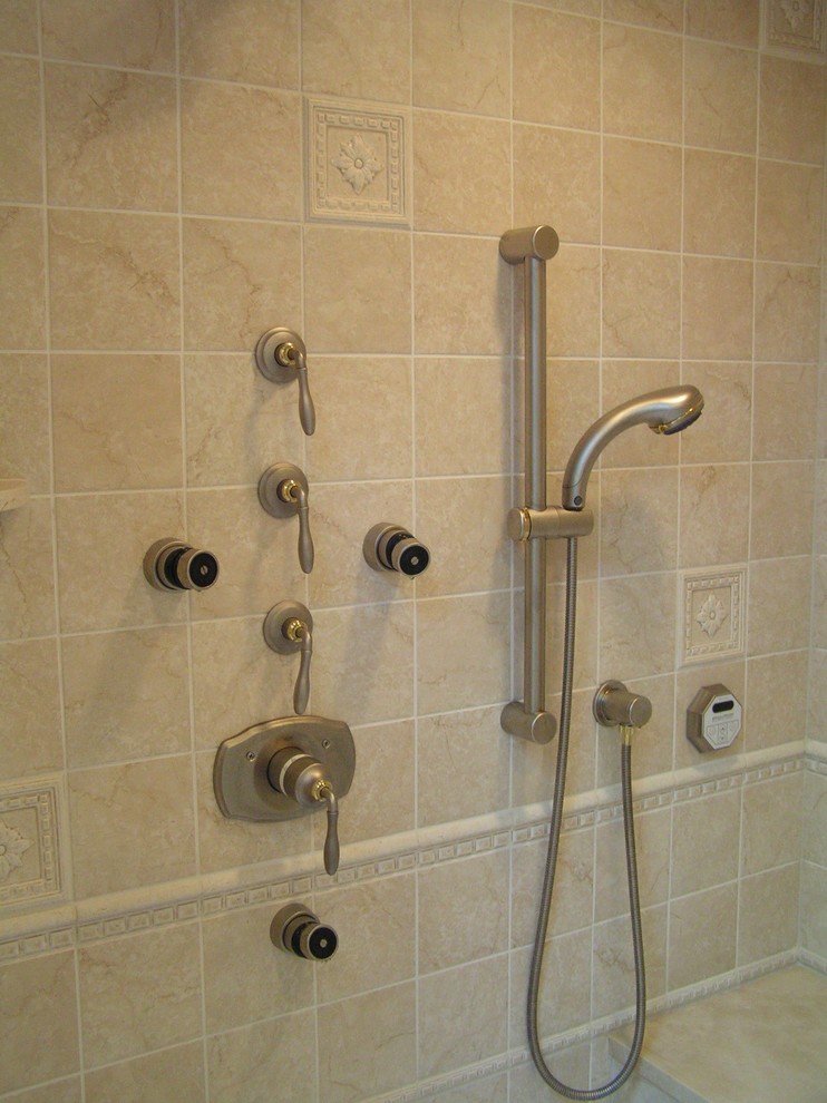 Exempel på ett stort klassiskt en-suite badrum, med ett undermonterad handfat, luckor med profilerade fronter, beige skåp, ett undermonterat badkar, en dusch/badkar-kombination, beige kakel, porslinskakel, beige väggar och klinkergolv i porslin
