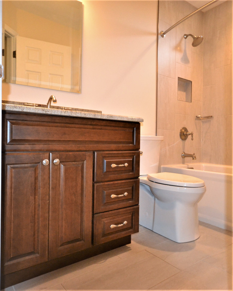 Inredning av ett klassiskt stort flerfärgad flerfärgat en-suite badrum, med luckor med upphöjd panel, skåp i mörkt trä, ett badkar i en alkov, en toalettstol med hel cisternkåpa, beige kakel, keramikplattor, beige väggar, klinkergolv i keramik, ett integrerad handfat, granitbänkskiva, beiget golv, dusch med duschdraperi och en dusch/badkar-kombination