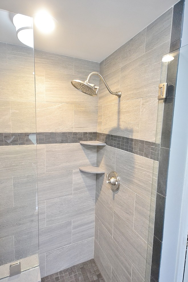 Example of a large classic master beige tile and ceramic tile ceramic tile and brown floor bathroom design in Philadelphia with raised-panel cabinets, medium tone wood cabinets, a one-piece toilet, gray walls, granite countertops, an undermount sink and a hinged shower door