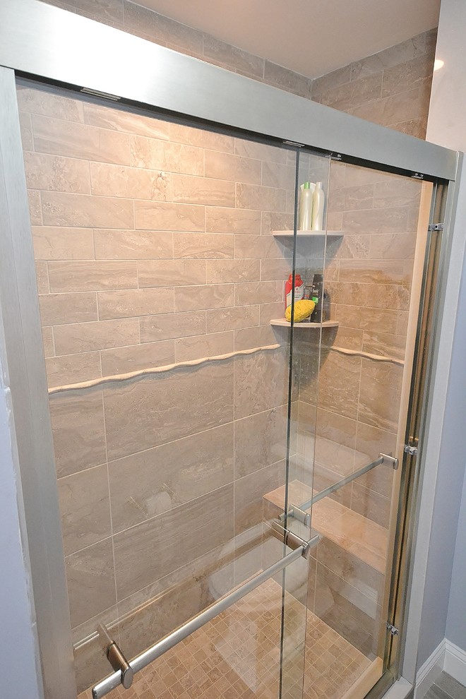 Cette photo montre une salle de bain chic avec un carrelage beige, des carreaux de céramique, un mur gris, un sol en carrelage de céramique, un sol gris et une cabine de douche à porte coulissante.
