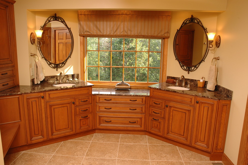 Example of a mid-sized classic master beige tile travertine floor alcove shower design in Cincinnati with an undermount sink, raised-panel cabinets, medium tone wood cabinets, granite countertops and beige walls