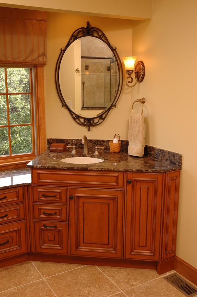 Klassisk inredning av ett mellanstort en-suite badrum, med ett undermonterad handfat, luckor med upphöjd panel, skåp i mellenmörkt trä, granitbänkskiva, beige väggar och travertin golv