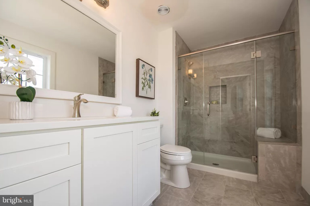Klassisk inredning av ett stort vit vitt en-suite badrum, med vita skåp, en dubbeldusch, en toalettstol med hel cisternkåpa, beige kakel, porslinskakel, vita väggar, klinkergolv i porslin, ett undermonterad handfat, bänkskiva i kvarts, beiget golv och dusch med gångjärnsdörr