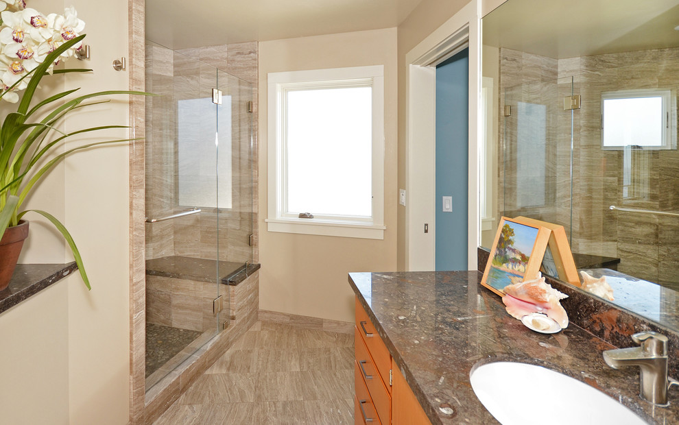 Cette photo montre une douche en alcôve principale bord de mer en bois clair avec un lavabo encastré, un placard à porte plane, un plan de toilette en granite, un carrelage beige, des carreaux de porcelaine, un mur blanc et un sol en travertin.