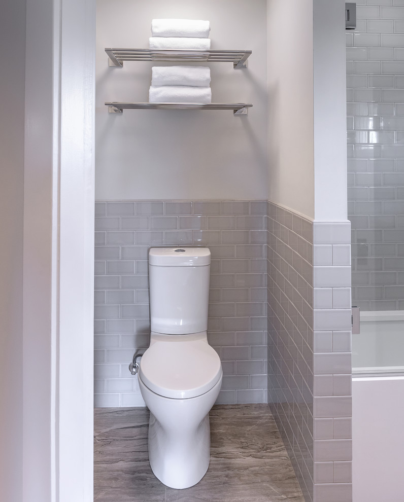 Réalisation d'un petit sauna craftsman en bois clair avec un placard à porte plane, un combiné douche/baignoire, WC à poser, un carrelage gris, des carreaux de céramique, un mur gris, un lavabo encastré, un plan de toilette en quartz, un sol beige, une cabine de douche à porte battante et un plan de toilette blanc.