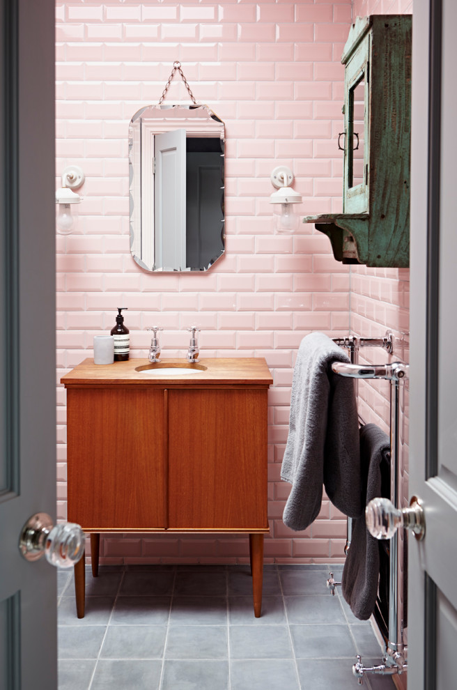Stilmix Badezimmer En Suite mit hellbraunen Holzschränken, rosa Fliesen, Metrofliesen, Schieferboden, grauem Boden, freistehendem Waschtisch, flächenbündigen Schrankfronten, Unterbauwaschbecken, Waschtisch aus Holz, brauner Waschtischplatte und Einzelwaschbecken in London