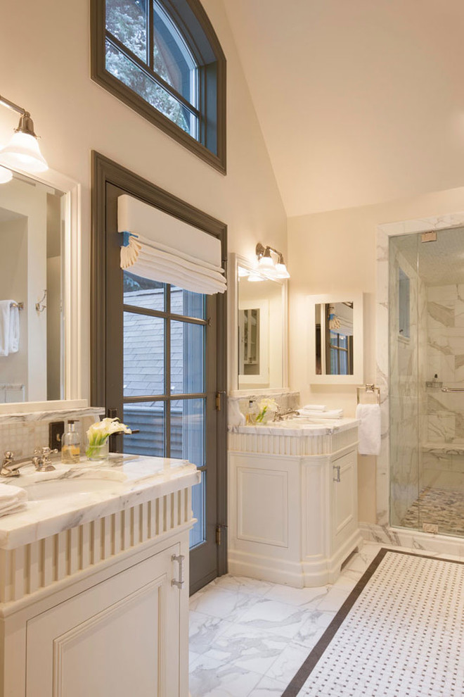 デンバーにあるトラディショナルスタイルのおしゃれな浴室 (アンダーカウンター洗面器、落し込みパネル扉のキャビネット、白いキャビネット、アルコーブ型シャワー、白いタイル、ベージュの壁) の写真