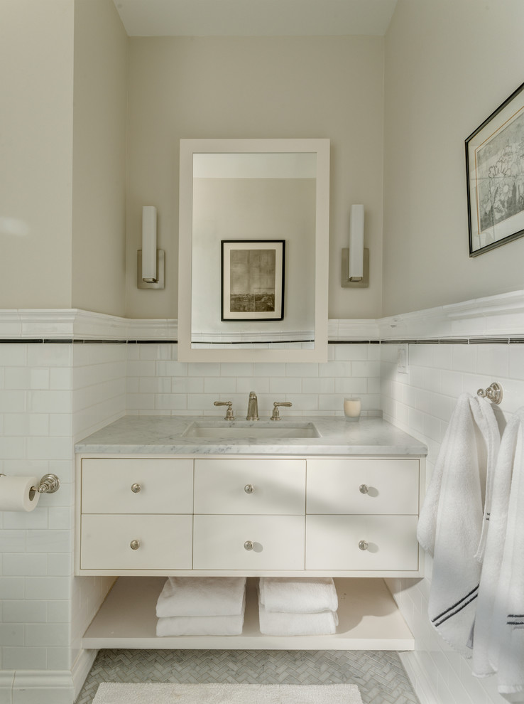Idéer för att renovera ett mellanstort vintage badrum med dusch, med möbel-liknande, vita skåp, en hörndusch, en vägghängd toalettstol, vit kakel, tunnelbanekakel, beige väggar, marmorgolv, ett undermonterad handfat, marmorbänkskiva, grått golv och dusch med gångjärnsdörr