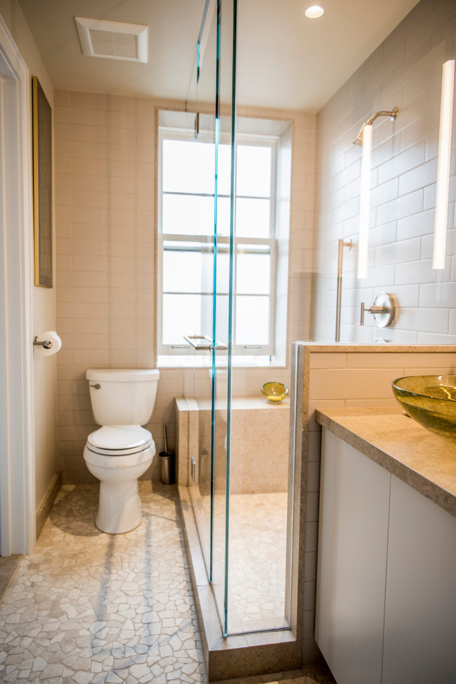 Example of a mid-sized trendy master white tile and mosaic tile pebble tile floor and beige floor corner shower design in New York with flat-panel cabinets, white cabinets, an undermount tub, a two-piece toilet, brown walls, an undermount sink, granite countertops and a hinged shower door