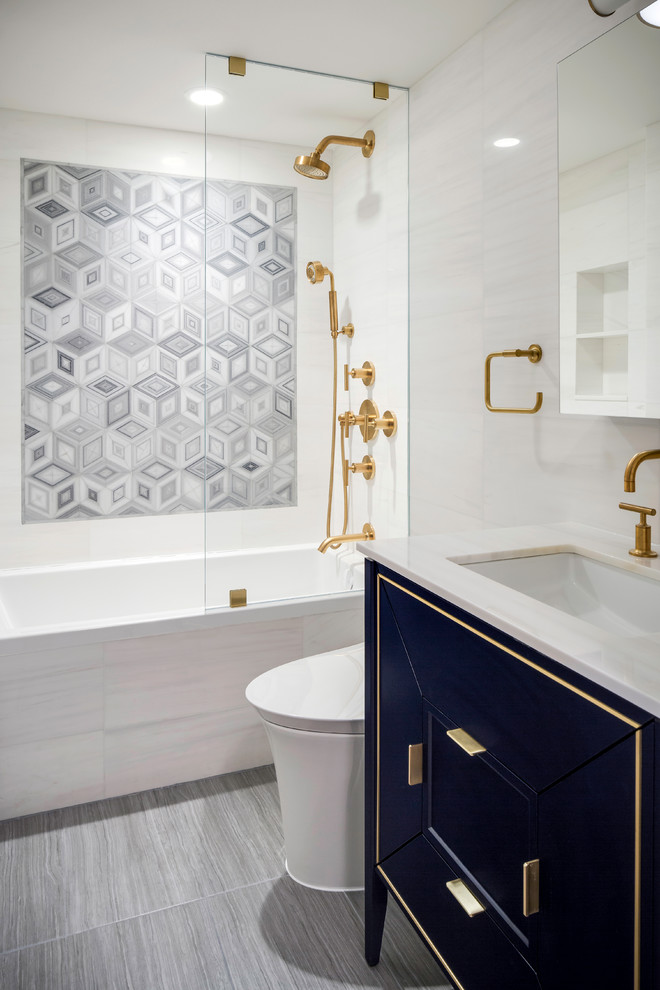 Modern inredning av ett beige beige badrum, med ett badkar i en alkov, en dusch/badkar-kombination, beige kakel, grå kakel, beige väggar, ett undermonterad handfat, grått golv och släta luckor