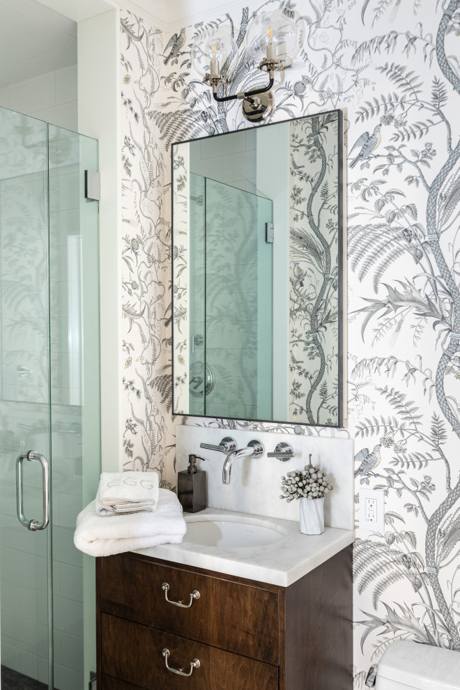 Transitional wallpaper bathroom photo in New York with flat-panel cabinets, dark wood cabinets, gray walls, an undermount sink and white countertops