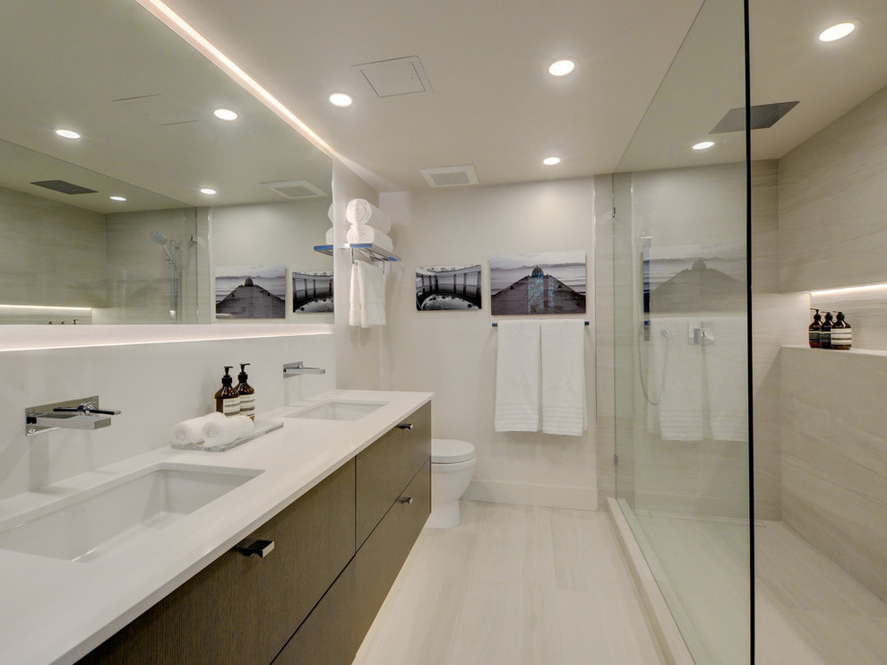 Inredning av ett modernt badrum med dusch, med släta luckor, skåp i mörkt trä, en dusch i en alkov, grå kakel, grå väggar, ett undermonterad handfat, grått golv och med dusch som är öppen