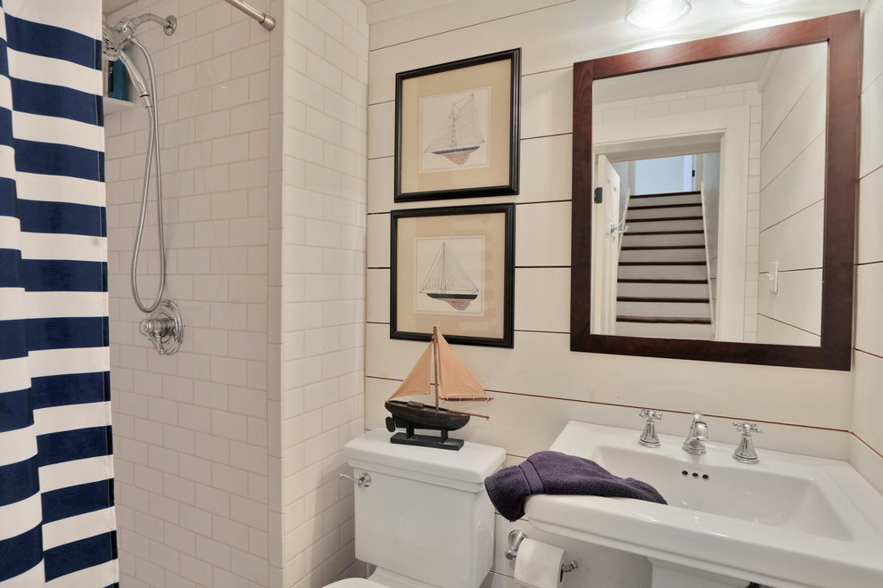 Bild på ett mellanstort lantligt badrum med dusch, med öppna hyllor, en dusch i en alkov, en toalettstol med hel cisternkåpa, vit kakel, beige väggar, ett piedestal handfat, bänkskiva i akrylsten och dusch med duschdraperi