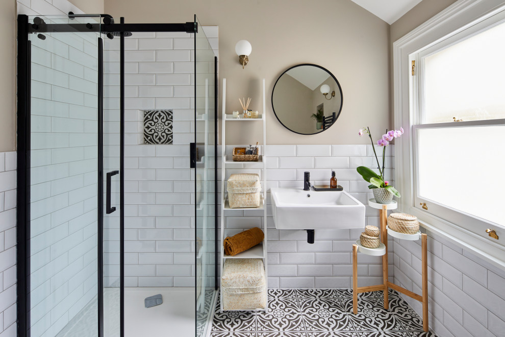 Inspiration for a medium sized contemporary ensuite bathroom in Surrey with a corner shower, white tiles, porcelain tiles, white walls, porcelain flooring, black floors, a single sink and a floating vanity unit.