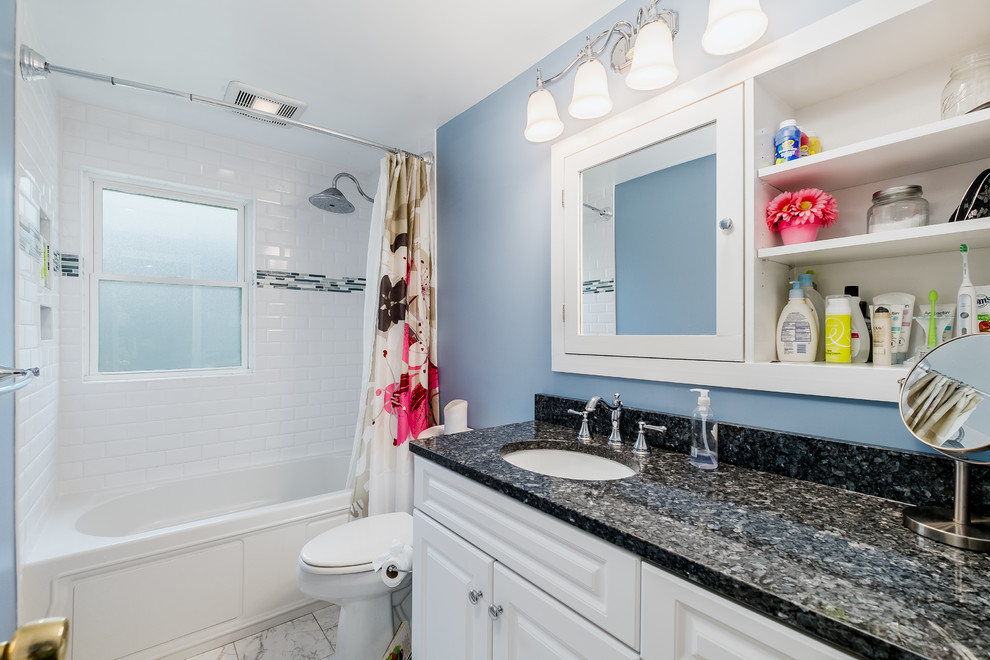 Idées déco pour une salle de bain avec des portes de placard blanches, un combiné douche/baignoire, un carrelage blanc, un carrelage métro, un plan de toilette en granite, une cabine de douche avec un rideau et un plan de toilette bleu.