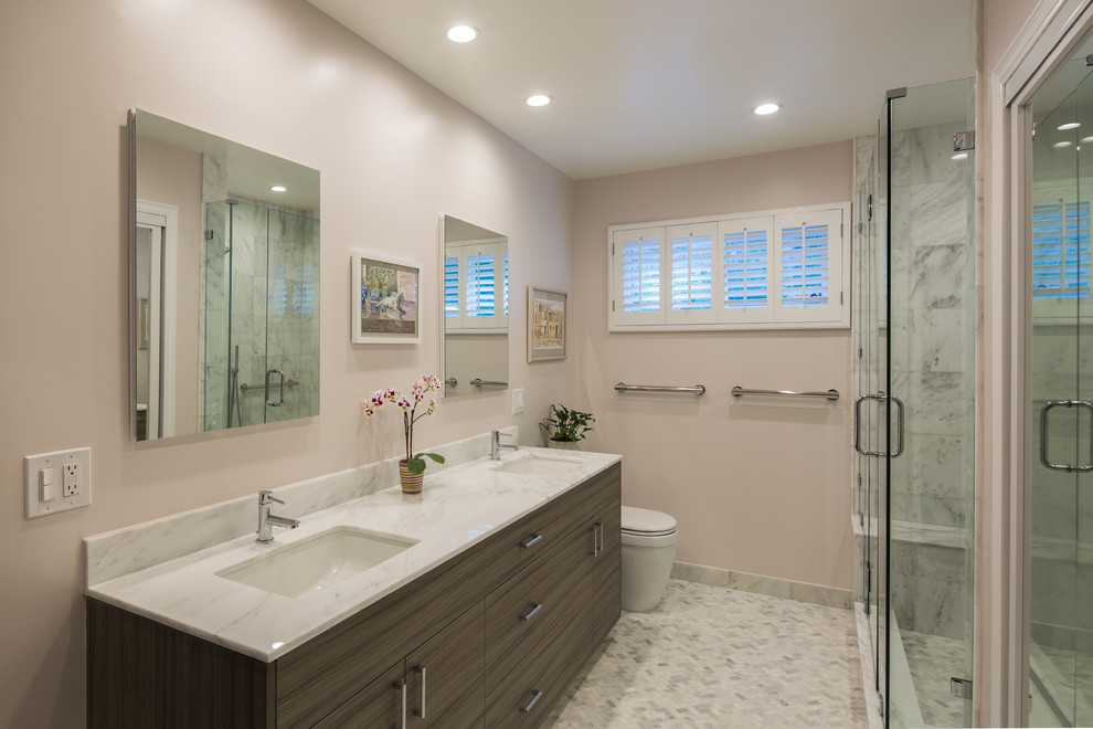 Example of a mid-sized trendy master white tile and stone tile marble floor bathroom design in Los Angeles with an undermount sink, flat-panel cabinets, light wood cabinets, marble countertops, a one-piece toilet and pink walls
