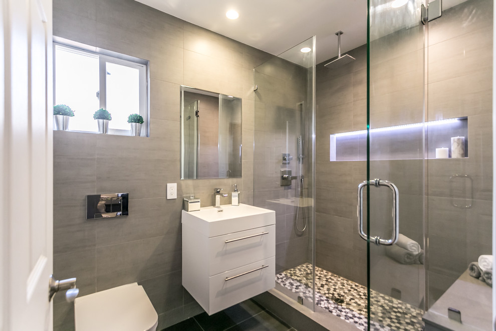 Immagine di una sauna design di medie dimensioni con ante bianche, WC sospeso, piastrelle grigie, piastrelle in gres porcellanato, pareti grigie, pavimento in gres porcellanato e lavabo integrato
