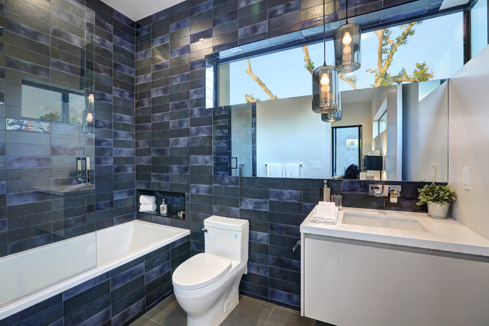 Modernes Duschbad mit flächenbündigen Schrankfronten, grauen Schränken, Einbaubadewanne, Toilette mit Aufsatzspülkasten, Unterbauwaschbecken und grauem Boden in Los Angeles