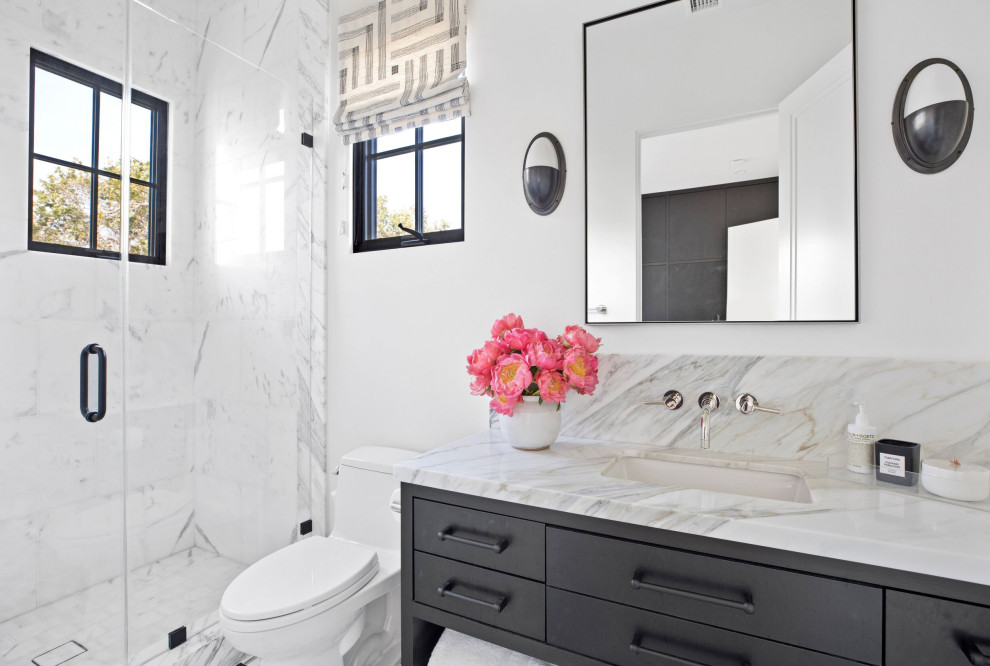 Источник вдохновения для домашнего уюта: большая ванная комната в стиле неоклассика (современная классика) с плоскими фасадами, черными фасадами, отдельно стоящей ванной, душем в нише, унитазом-моноблоком, белой плиткой, мраморной плиткой, белыми стенами, мраморным полом, душевой кабиной, врезной раковиной, мраморной столешницей, белым полом, душем с распашными дверями, серой столешницей, сиденьем для душа, тумбой под одну раковину, встроенной тумбой и кессонным потолком
