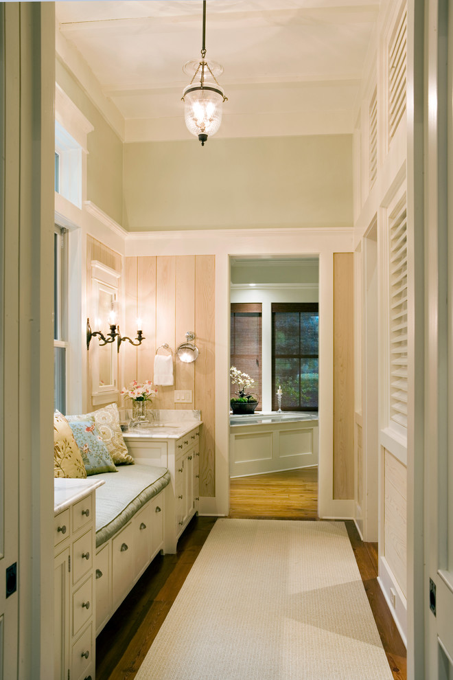 Elegant corner bathtub photo in Atlanta with white cabinets