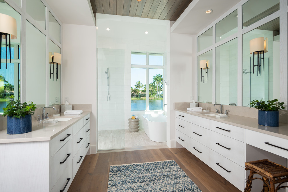 Idéer för vintage beige en-suite badrum, med släta luckor, vita skåp, ett fristående badkar, en öppen dusch, vita väggar, mellanmörkt trägolv, ett undermonterad handfat och brunt golv