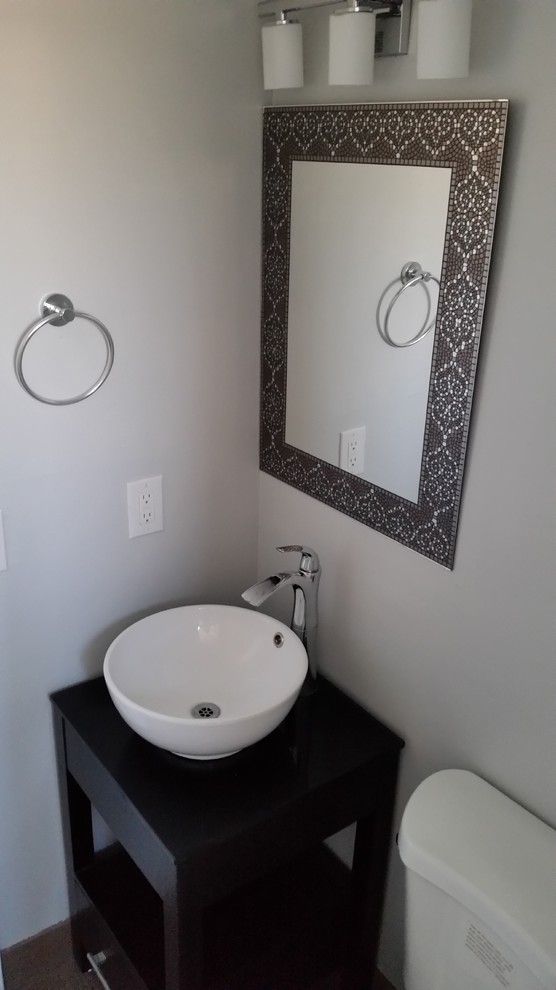 Photo of a small traditional shower room bathroom in Salt Lake City with open cabinets, dark wood cabinets, a two-piece toilet, beige tiles, ceramic tiles, grey walls, ceramic flooring, a vessel sink and glass worktops.